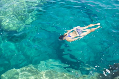 Hispanic woman swimming in ocean