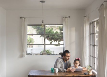 Hispanic father and daughter using digital tablet