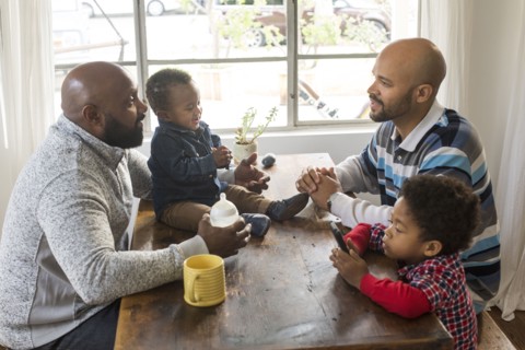 Fathers and children sitting at table