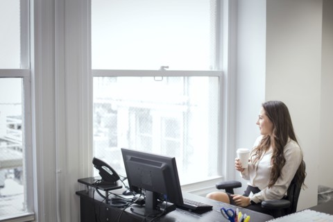 Caucasian businesswoman looking out office window