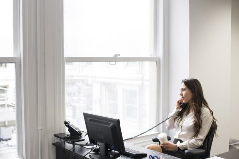 Caucasian businesswoman talking on telephone in office
