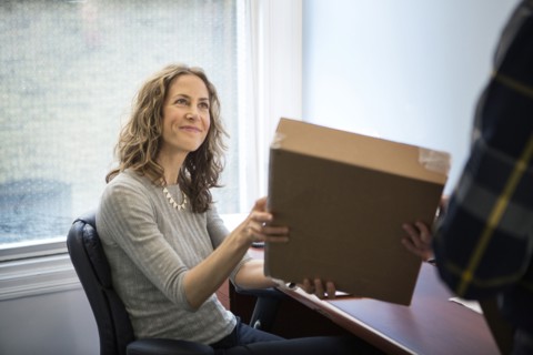 Caucasian businessman delivering packages in office