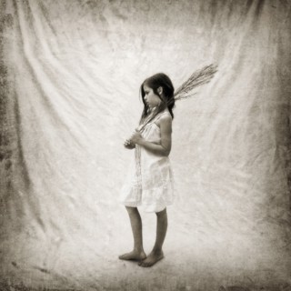 Photograph of girl holding branch on fabric