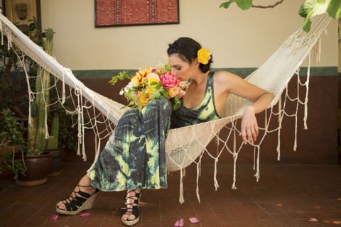Woman smelling bouquet of flowers in hammock