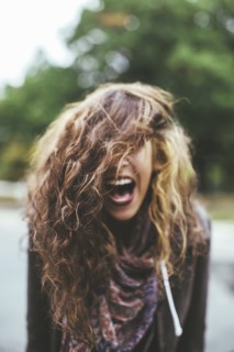 Shouting Middle Eastern woman tossing her hair outdoors