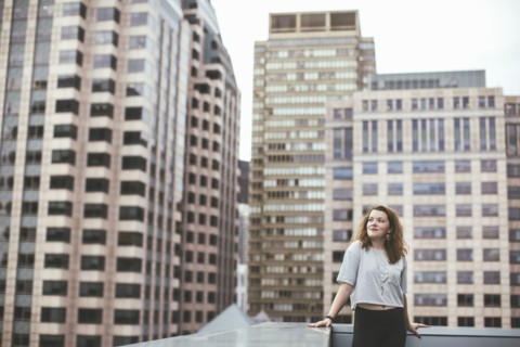 Caucasian woman on urban rooftop admiring cityscape
