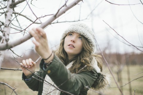 Caucasian woman examining tree branches