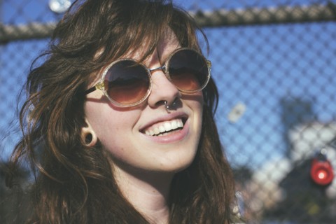 Caucasian woman wearing sunglasses at fence