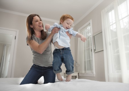 Mother and son playing on bed