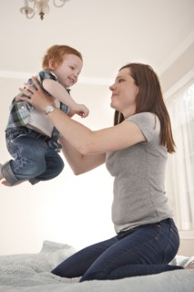 Mother and son playing on bed