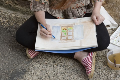 Caucasian girl drawing on concrete ground