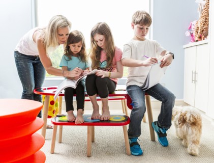 Caucasian family drawing at table in playroom