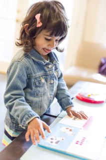 Close up of girl reading book at table