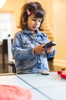 Girl watching television with remote control