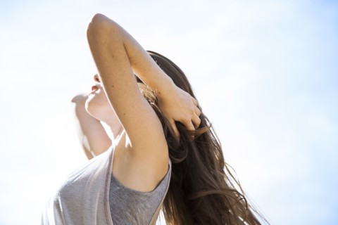 Caucasian woman standing under blue sky