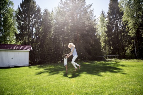 Mother playing with son in backyard