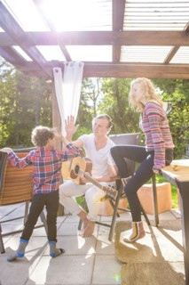 Father and son high-fiving on backyard patio