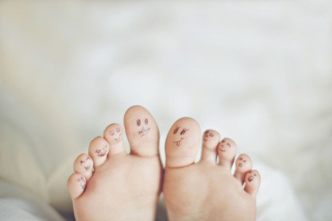 Toes of Caucasian girl with smiley face drawings