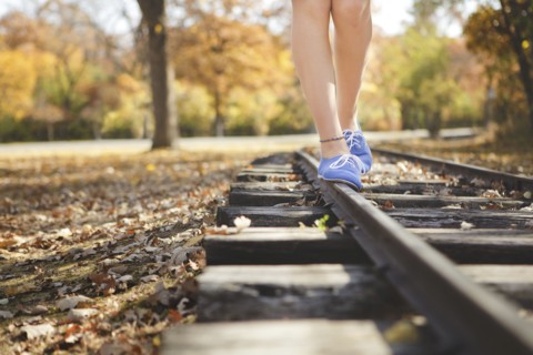 Caucasian girl balancing on train tracks