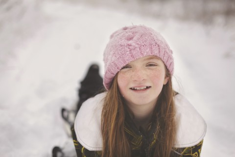 Caucasian girl laying in snow