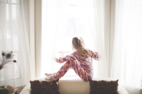 Caucasian girl sitting in window