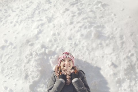 Caucasian girl laying in snow