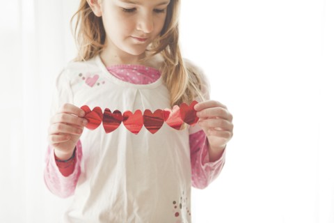 Caucasian girl holding heart-shaped bunting