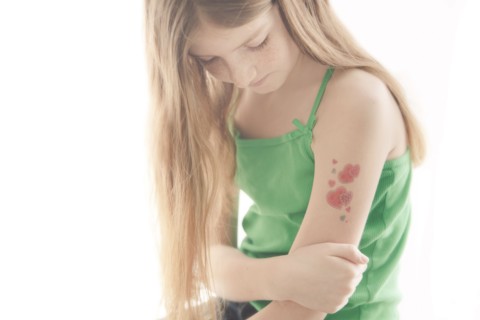 Caucasian girl with temporary tattoo on arm