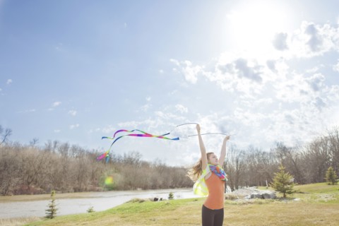 Caucasian girl playing with ribbons in park