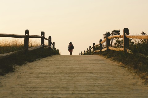 Silhouette of woman walking on wooden walkway