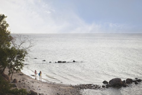 Caucasian girls standing on remote beach