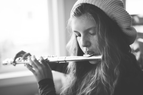 Close up of Caucasian girl playing flute