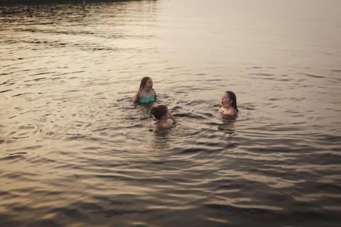 Caucasian girls swimming in lake