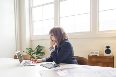 Businesswoman using laptop at desk in office