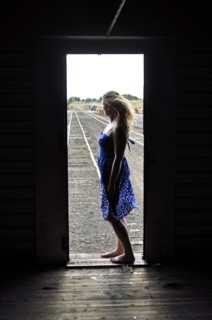 Woman standing in doorway of train in train yard