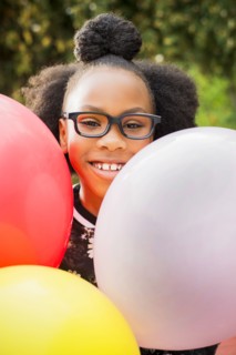 Black girl holding bunch of balloons