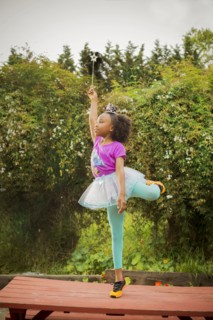 Black girl playing ballerina on picnic table