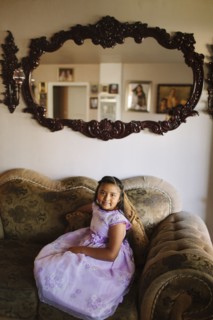 Hispanic girl sitting on living room sofa
