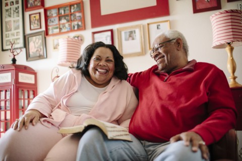 Couple reading book in living room