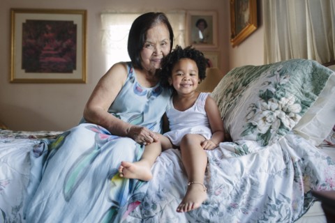 Grandmother and granddaughter hugging on bed