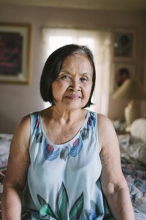 Smiling older woman sitting on bed