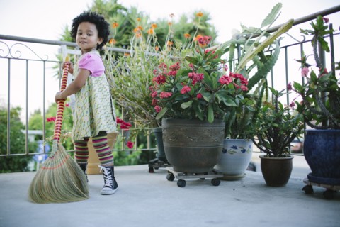 Girl sweeping patio with broom