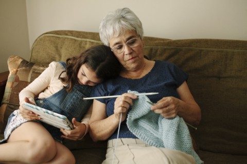 Grandmother and granddaughter relaxing in living room