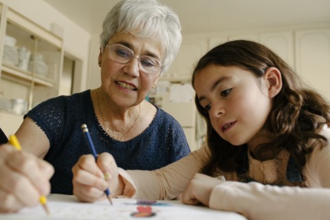 Grandmother and granddaughter drawing at table