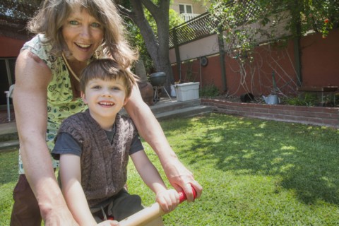 Caucasian grandmother and grandson riding bicycle in backyard