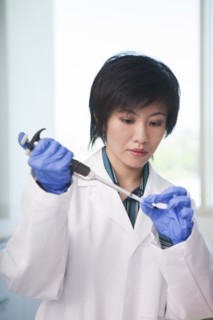 Scientist pipetting liquid into test tube in laboratory