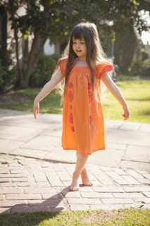Caucasian girl playing barefoot in backyard