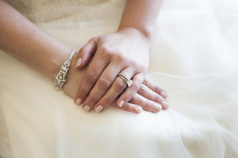 Caucasian bride wearing rings and wedding gown
