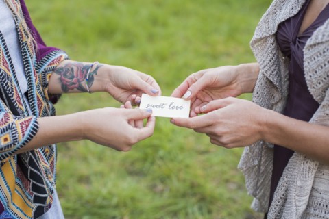Close up of friends holding sweet love card