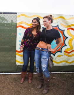 Women smiling near multicolor mural